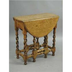 A small 1920's oak gate leg table on open twist turned supports