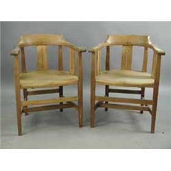 A pair of oak Arts and Crafts tub chairs with pierced splats and solid seats. Est.200/40