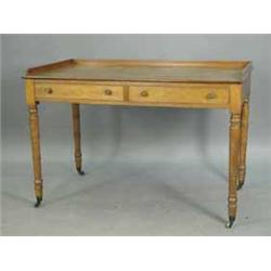 A Victorian oak writing table with a low 3/4 gallery over two frieze drawers and ring turned legs