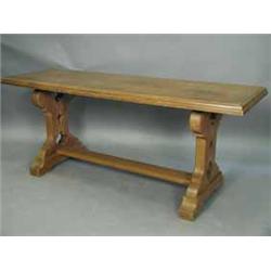 An Arts and Crafts oak refectory table with shaped end supports