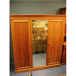 An Aesthetic movement pitch pine triple wardrobe with applied imitation bamboo mouldings.  Bears a H