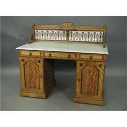 An Aesthetic movement satin walnut(?) washstand with a marble top and tiled back on a kneehole base