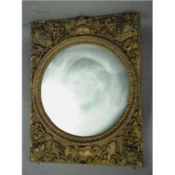 A 'gilt' wall mirror with a circular mirror and papier mache applied motifs. 116cm high Est.100/20