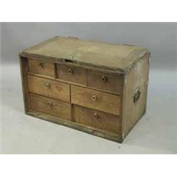 A l9th Century oak table cabinet with a hinged door enclosing seven short drawers