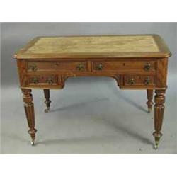 A Victorian oak kneehole writing table with four drawers on turned and reeded legs