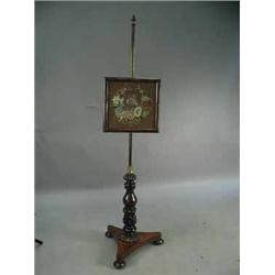 A Victorian mahogany pole screen with an adjustable framed embroidered screen