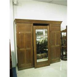 An Arts and Crafts oak triple wardrobe