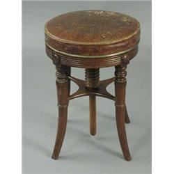 A good Regency mahogany piano stool with an adjustable seat on turned