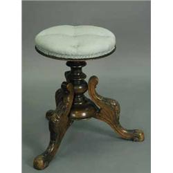 A Victorian walnut revolving piano stool with a carved frame and an upholstered seat Est.250/30