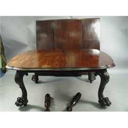 A good Victorian mahogany extending dining table with 3 leaves and serpentine ends on boldly carved 