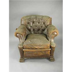 A South African leather upholstered arm chair on carved paw feet