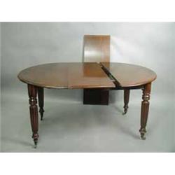 A Victorian mahogany extending dining table with 'D' shaped ends and two leaves on turned and reeded