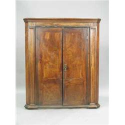 A George II walnut two door corner cupboard