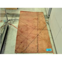 Small rust colored wool throw rug