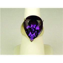 Stylish 10 karat heavy yellow gold ladies  ribbed design ring set with a large pear  shape Amethyst 