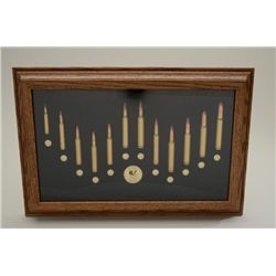 Framed modern cartridge board by Tatonka  Cartridge Co. approx. 12” x 18” showing 12  cartridges fro