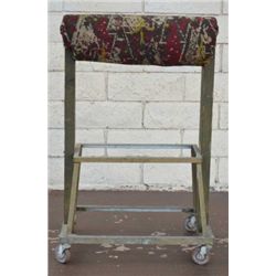 Antique large metal frame saddle stand on  wheels with carpet bag material covering to  saddle suppo