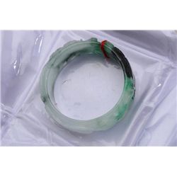 One attractive wide bangle bracelet in  varying color of green and intricate carving.  Est.:$200-$40