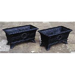 A pair of cast iron planters of square tapering form, the fluted sides cast in relief with a central