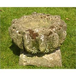 A sandstone birdbath of roughly hewn form, the lobed bowl on square base, 31 high x 44cm diameter (1
