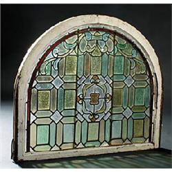 A pair of early 20th century stained glass windows, the central medallion within a geometric panel s