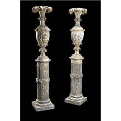 A pair of alabaster vases and pedestals, the elongated baluster shaped vases with everted rims, carv