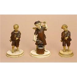 Three Austrian ivory and wood figures of putti, in 19th century style, one as a blacksmith, the othe