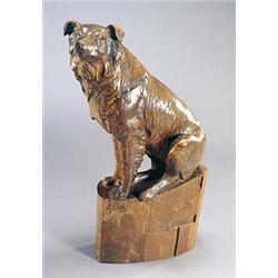 An early 20th century walnut figure of a sheepdog by L Prost, with carved detail seated on a curved.