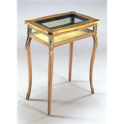 A French mahogany display table with gilt metal mounts, a hinged glazed top and sides, on slender ca