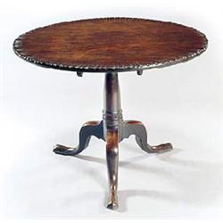 A George III mahogany tilt top table, the round dished top on a turned column and tripod base with p