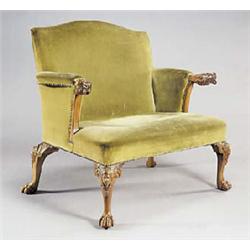 An early 20th century walnut armchair of wide proportions, with serpentine padded back, shaped sides