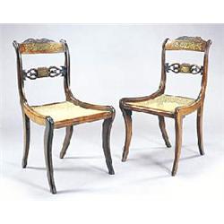 A pair of Regency rosewood and brass inlaid side chairs, each with a scroll carved crest, lyre shape