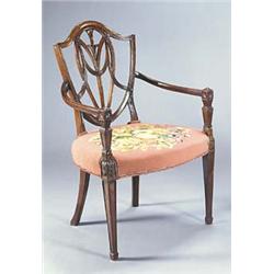 A mahogany shield back elbow chair with pierced and interlaced back, a woolwork upholstered seat and