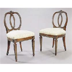 A pair of late 19th century North European ash and parcel gilt side chairs each with a carved crest.
