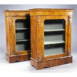 A pair of Victorian walnut bookcases, each with a moulded top, the crossbanded and boxwood strung fr