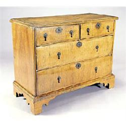 A walnut and feather banded chest, the crossbanded top with a moulded edge above two short and two l