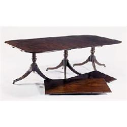 A mahogany three pillar dining table in Regency style with two loose leaves, the top with rounded co