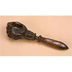 A carved wooden nut-cracker, in the form of a hand clutching a knurled bowl, with stiff leaf termina