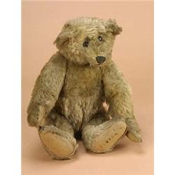 An early 20th century teddy bear, the fully jointed golden plush body stuffed with wood wool, with f