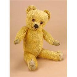 A 1950s Merrythought teddy bear, the fully jointed golden plush body with fabric pads and glass eyes