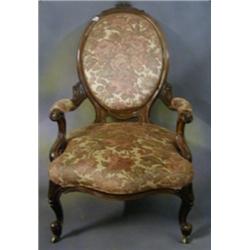 A Victorian carved walnutwood show frame spoon back open arm chair raised on cabriole supports