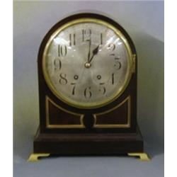 An Edwardian striking bracket clock with silvered dial and Arabic numerals contained in an arched