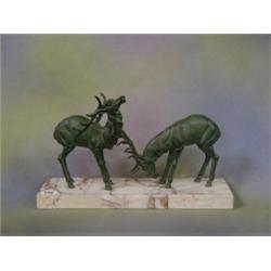 An Art Nouveau spelter verdigris figure group of 2 stags, raised on a rectangular marble base