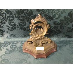 An ornate gilt watch holder.