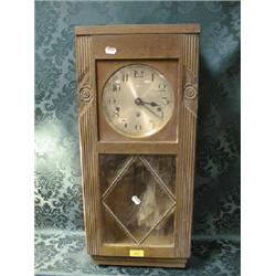 An early 20thC.. oak Art Deco wall clock with chiming 8-day movement  and bevel lozenge glass doo
