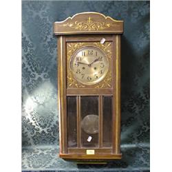 A 1930's oak and gilt decorated wall clock with 8-day movement and 3  bevel plates to the glass d