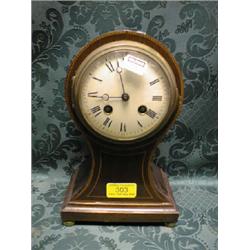 An Edwardian string inlaid mahogany balloon mantel clock on brass  feet, and having convex enamel