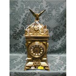 A late 19thC. brass table clock surmounted with an eagle over a  baroque style case with sunburst