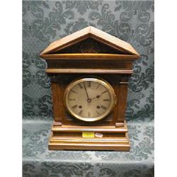 An Edwardian oak bracket clock of Palladian architectural form having  silvered dial with Roman n