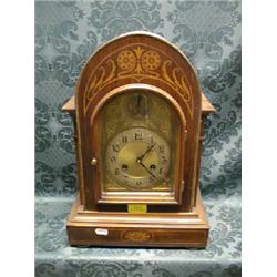 An Edwardian mahogany and marquetry bracket clock with brass arch  dial having silvered chapter a